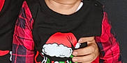 Kayleb is registered to the contest to win money with this photo: baby, black, child, christmas, clothing, cute, face, footwear, hair, hand, holiday, indoors, looking_sideways, nike, pajamas, person, plaid, red, sitting, toddler