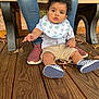 Kayleb is registered to the contest to win money with this photo: baby, child, infant, bib, plaid_shirt, shorts, checkered_shoes, wooden_deck, bench, adult, jeans, sneakers, autumn_leaves, outdoor, person, curious, reaching_hand, nature, casual_clothing, support