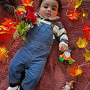 Kayleb joined the competition — help win amazing prizes! autumn_leaves, baby, blanket, child, cozy, cute, decorations, denim_overalls, fairy_lights, fall_theme, gnome_figurine, holiday, indoor, laying_down, pinecones, portrait, red_roses, soft_lighting, striped_shirt, white_socks