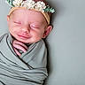 Penelope is registered to the contest to win money with this photo: newborn, baby, infant, sleeping, smiling, portrait, flower_crown, swaddled, blanket, gray, peaceful, face, head, hand, indoor, studio, photography, close_up, cute, child