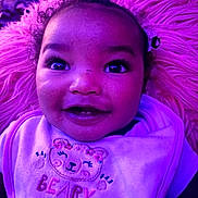 Milan joined the competition — help win amazing prizes! baby, child, smiling, face, bib, clothing, curly_hair, pink, purple_light, soft_texture, fluffy, portrait, indoor, cute, happy, topknot, closeup, infant, person, expression