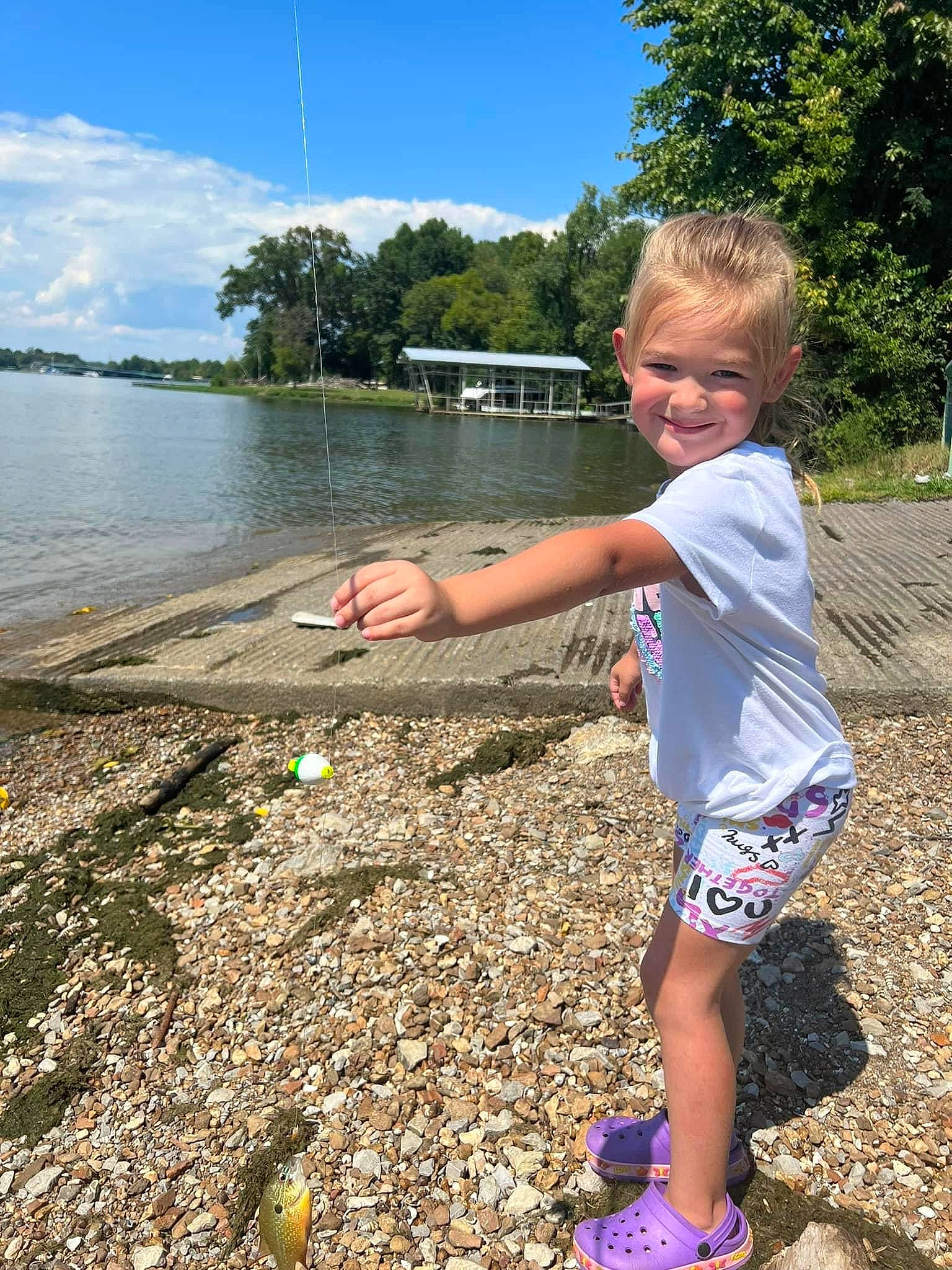 Jewell is registered to the contest to win money with this photo: child, fun, grass, happy, joy, lake, landscape, leisure, people_in_nature, person, plant, recreation, sand, shorts, sky, smile, t_shirt, toddler, tree, water