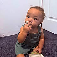 Zacarías joined the competition — help win amazing prizes! toddler, child, baby, sitting, pacifier, curious, portrait, indoor, carpet, floor, overalls, clothing, sandal, shoe, door, wall, home, infant, face, looking_up