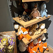 Belleza participe au concours pour gagner de l'argent avec cette photo : dog, stuffed_toys, plush, shelf, toy_store, sleeping, small_dog, wooden_shelf, lighting, shadows, decor, flowers, fox_plush, doll, display, retail, cute, cozy, indoor, pet