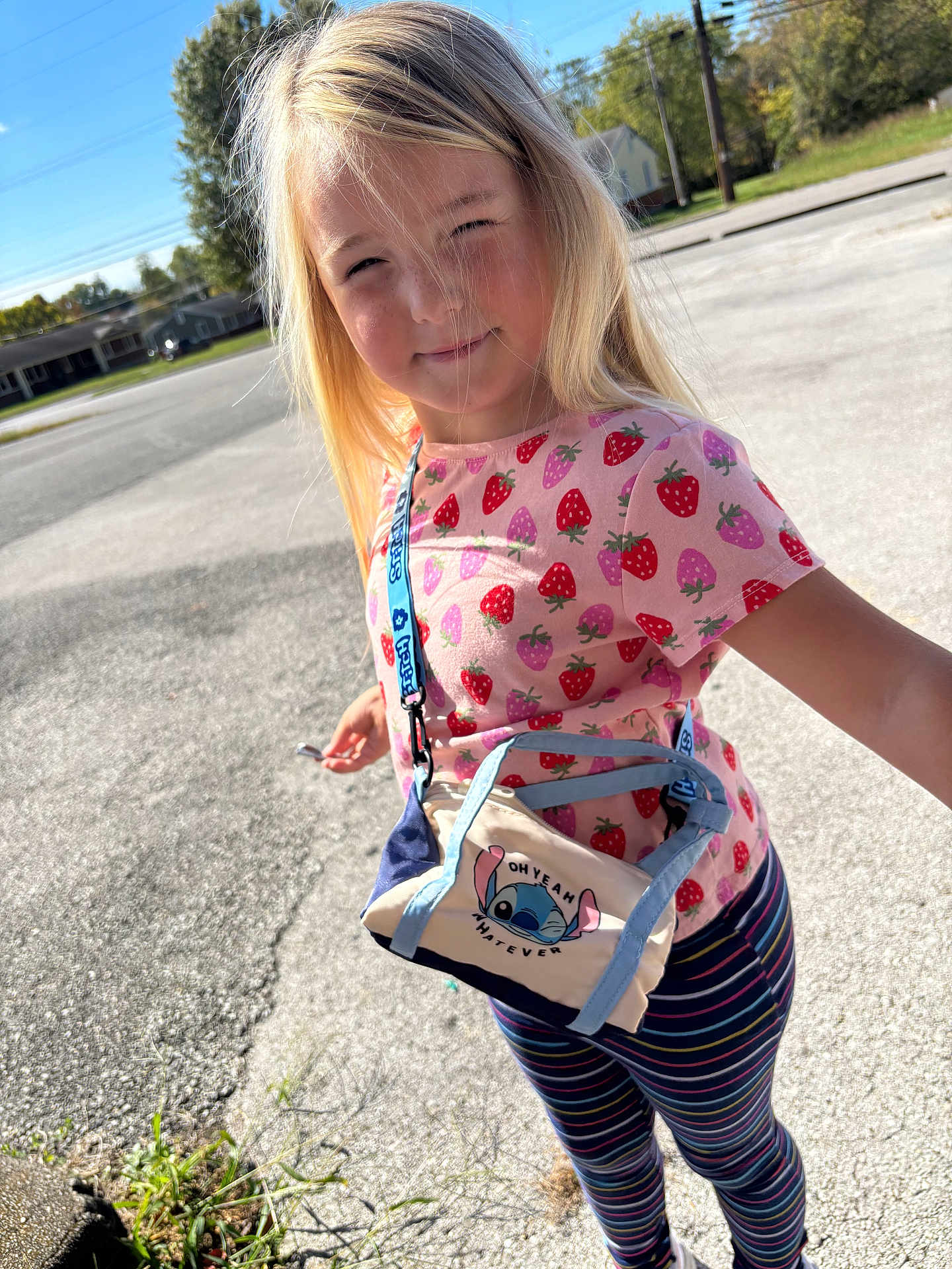 Mika joined the competition — help win amazing prizes! child, blonde_hair, pink_shirt, strawberry_pattern, striped_leggings, small_bag, stitch_character, outdoor, sunlight, sidewalk, street, trees, houses, blue_sky, smiling, person, standing, casual_clothing, daytime, accessory