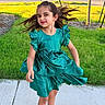 child, girl, dress, green_dress, toddler, happy, smiling, hair, long_hair, outdoor, sidewalk, grass, lawn, suburb, street, sneakers, playful, sunlight, portrait, person