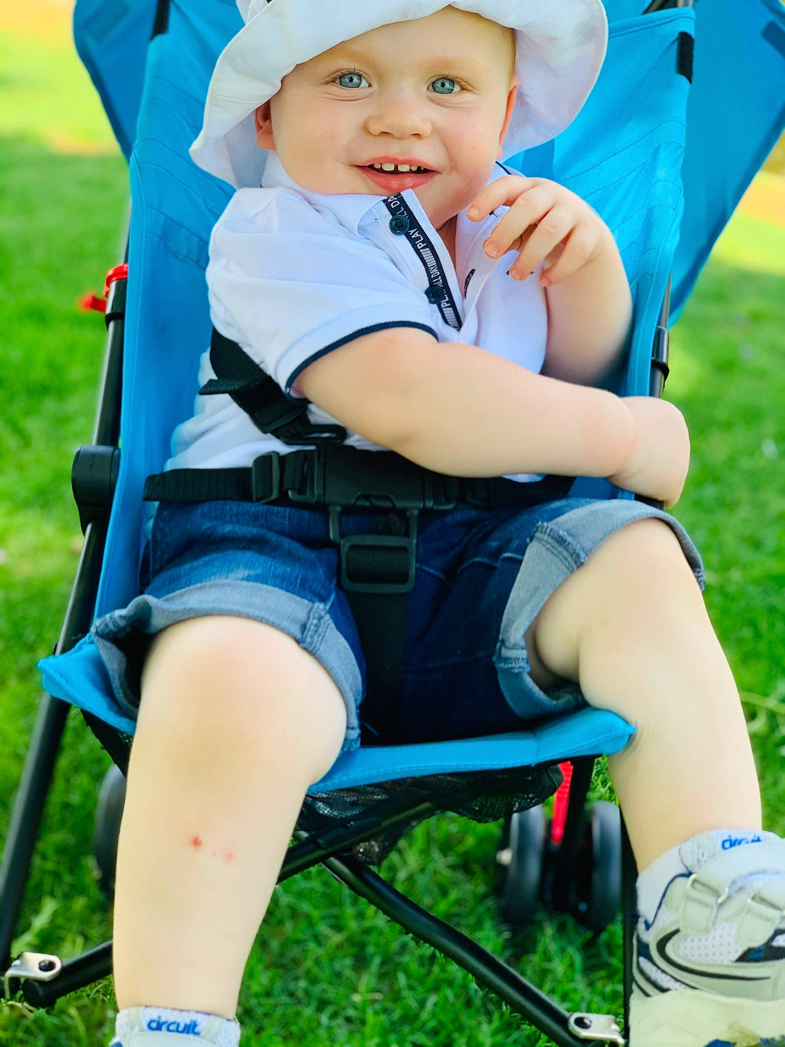 Tex is registered to the contest to win money with this photo: baby, baby_carriage, baby_products, child, fun, grass, happy, joy, leg, leisure, outdoor_play_equipment, person, plant, play, playground, product, public_space, sitting, smile, summer