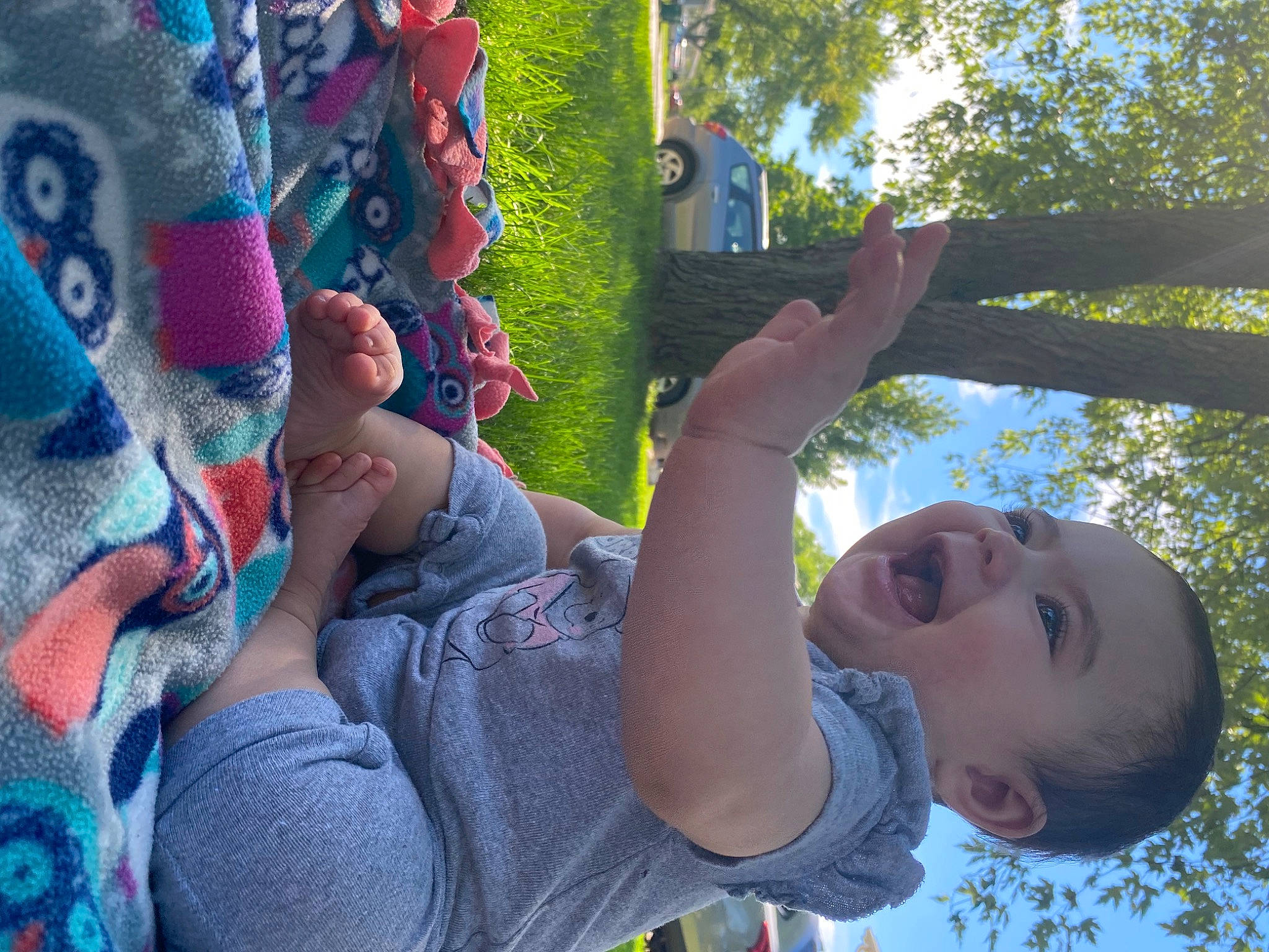 Luna is registered to the contest to win money with this photo: blue, cool, finger, fun, gesture, grass, hand, happy, leaf, leisure, people_in_nature, person, photograph, plant, public_space, sky, smile, summer, toddler, tree