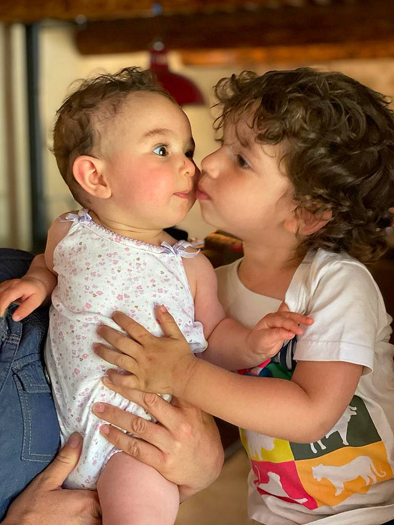 Inaya participe au concours pour gagner de l'argent avec cette photo : baby_toddler_clothing, cheek, drinkware, eye, face, finger, gesture, hairstyle, hand, happy, head, interaction, iris, kiss, lip, mouth, neck, nose, person, plant