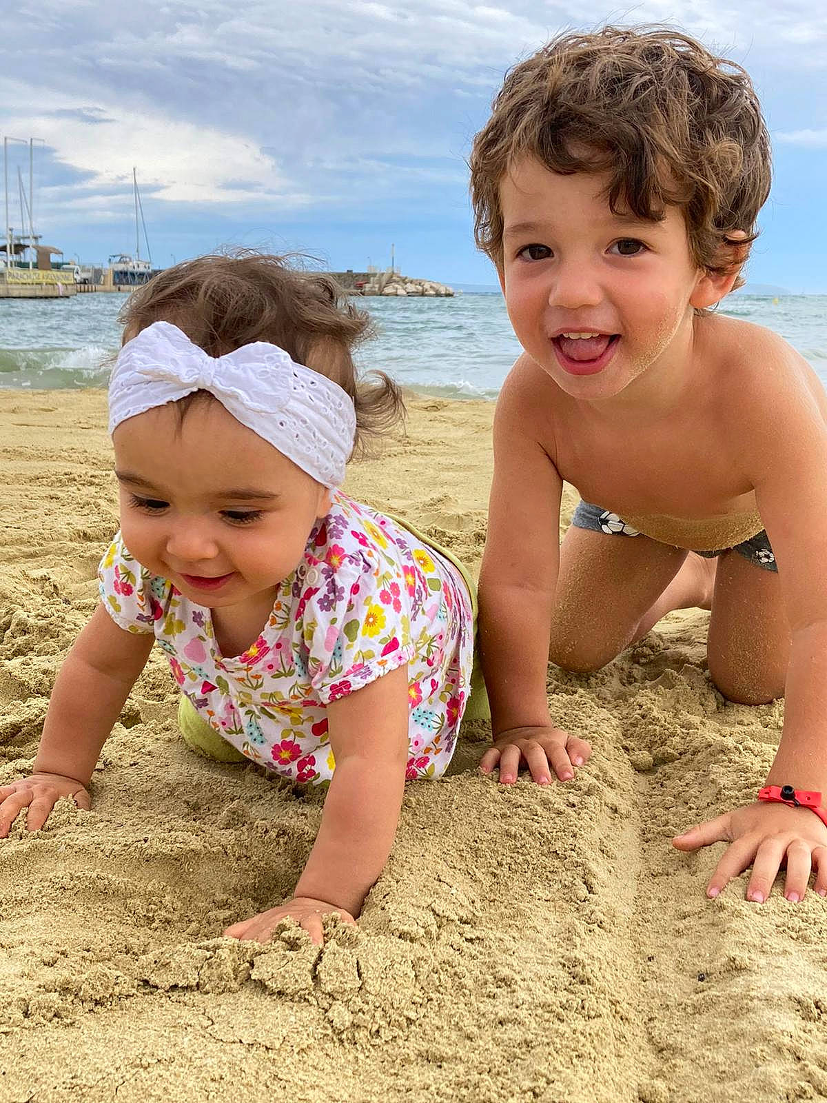 Inaya participe au concours pour gagner de l'argent avec cette photo : beach, child, cloud, eye, fun, happy, hat, head, headwear, human, joy, leisure, people_in_nature, people_on_beach, person, sand, shore, sitting, sky, smile