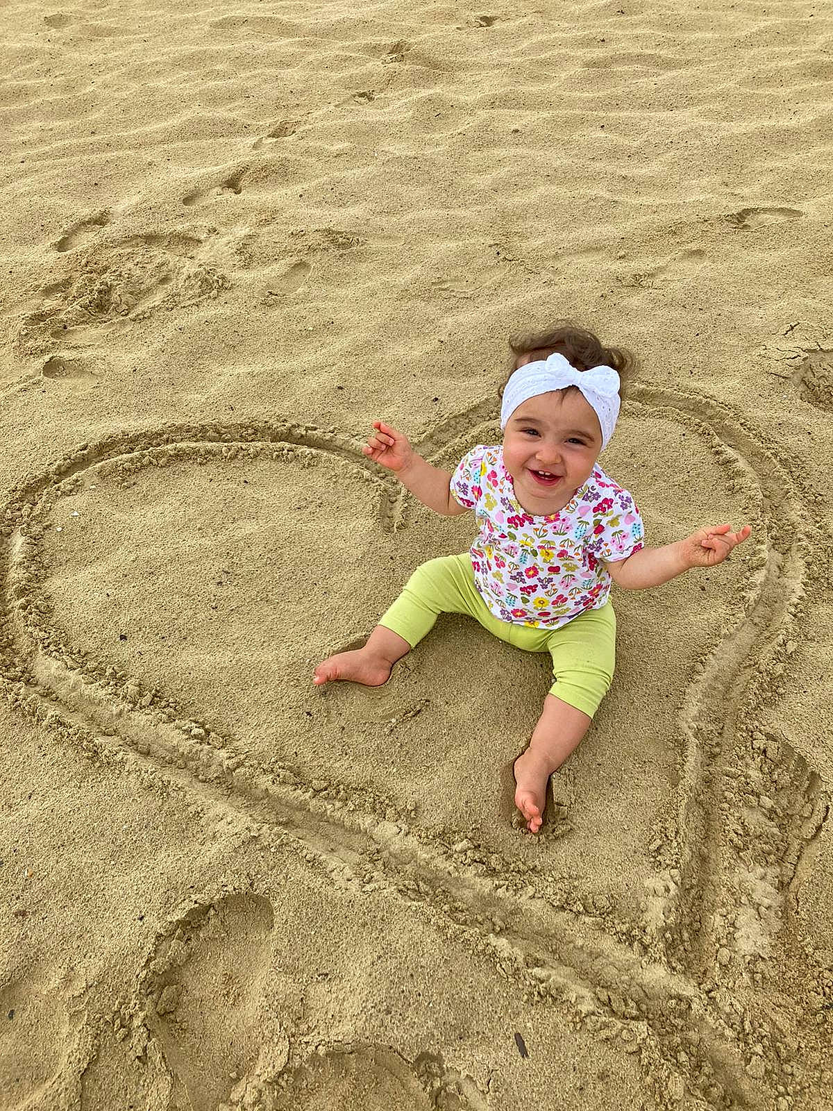 Inaya a rejoint le concours — aidez-le/la à gagner de superbes lots ! aeolian_landform, baby, beach, body_of_water, child, ecoregion, fun, grass, happy, headwear, joy, landscape, leisure, people_in_nature, people_on_beach, person, play, recreation, shadow, smile