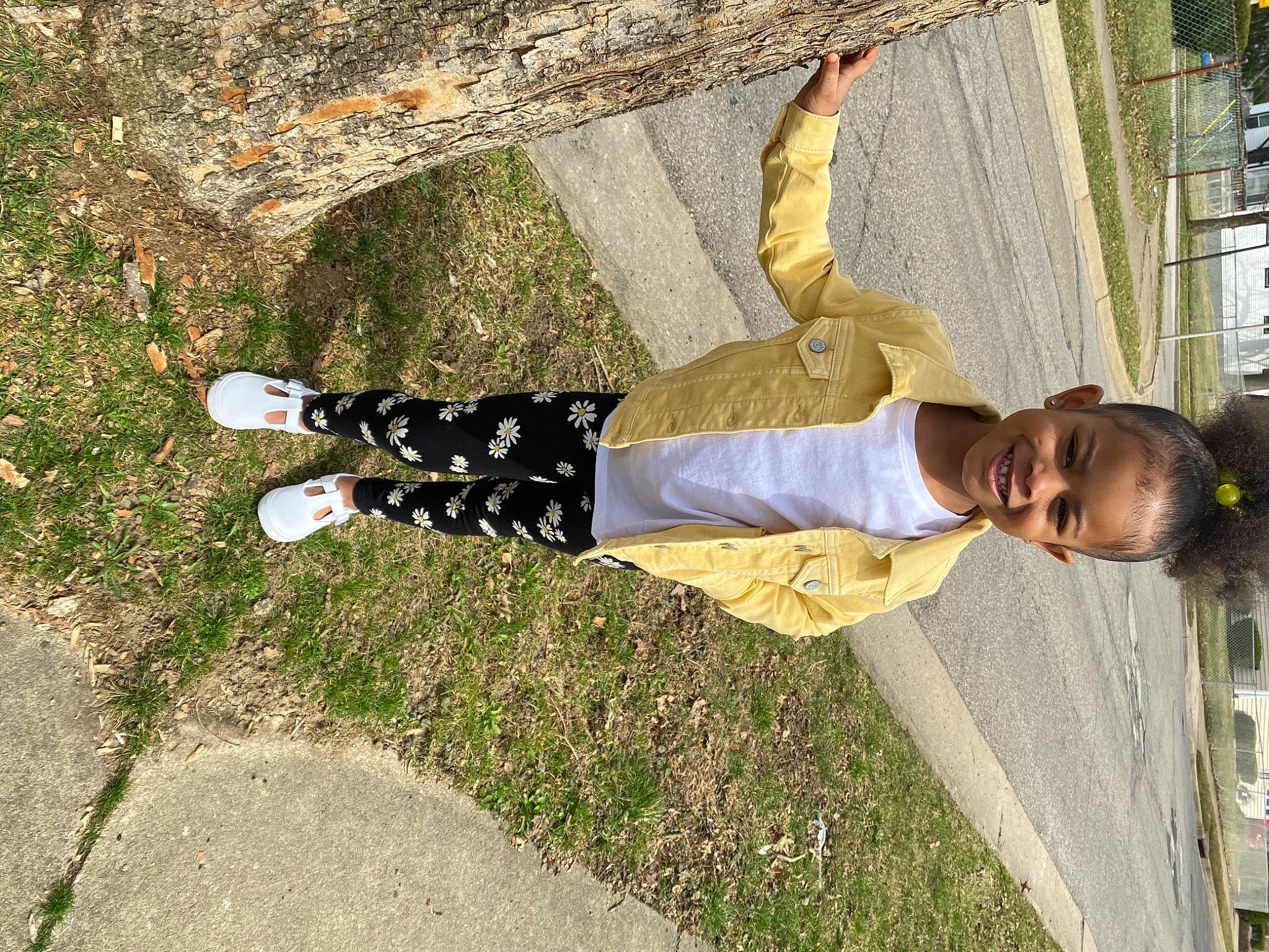 Kaylee is registered to the contest to win money with this photo: gesture, grass, happy, human_leg, joy, leisure, pedestrian, people_in_nature, person, plant, recreation, road_surface, shadow, shoe, sidewalk, sneakers, street_fashion, tree, trunk, walking_shoe