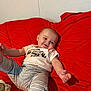 Bennett joined the competition — help win amazing prizes! baby, infant, smile, red_quilt, striped_pants, white_shirt, tiny_explorer, couch, blanket, indoor, cute, happy, child, portrait, relaxing, cozy, playful, person, young_child, casual_clothing