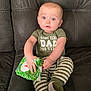 Bennett joined the competition — help win amazing prizes! baby, infant, child, onesie, striped_pants, green_clothing, wipes_package, couch, leather, sitting, blue_eyes, curious, indoors, young_child, cute, portrait, hands, feet, expression, fabric