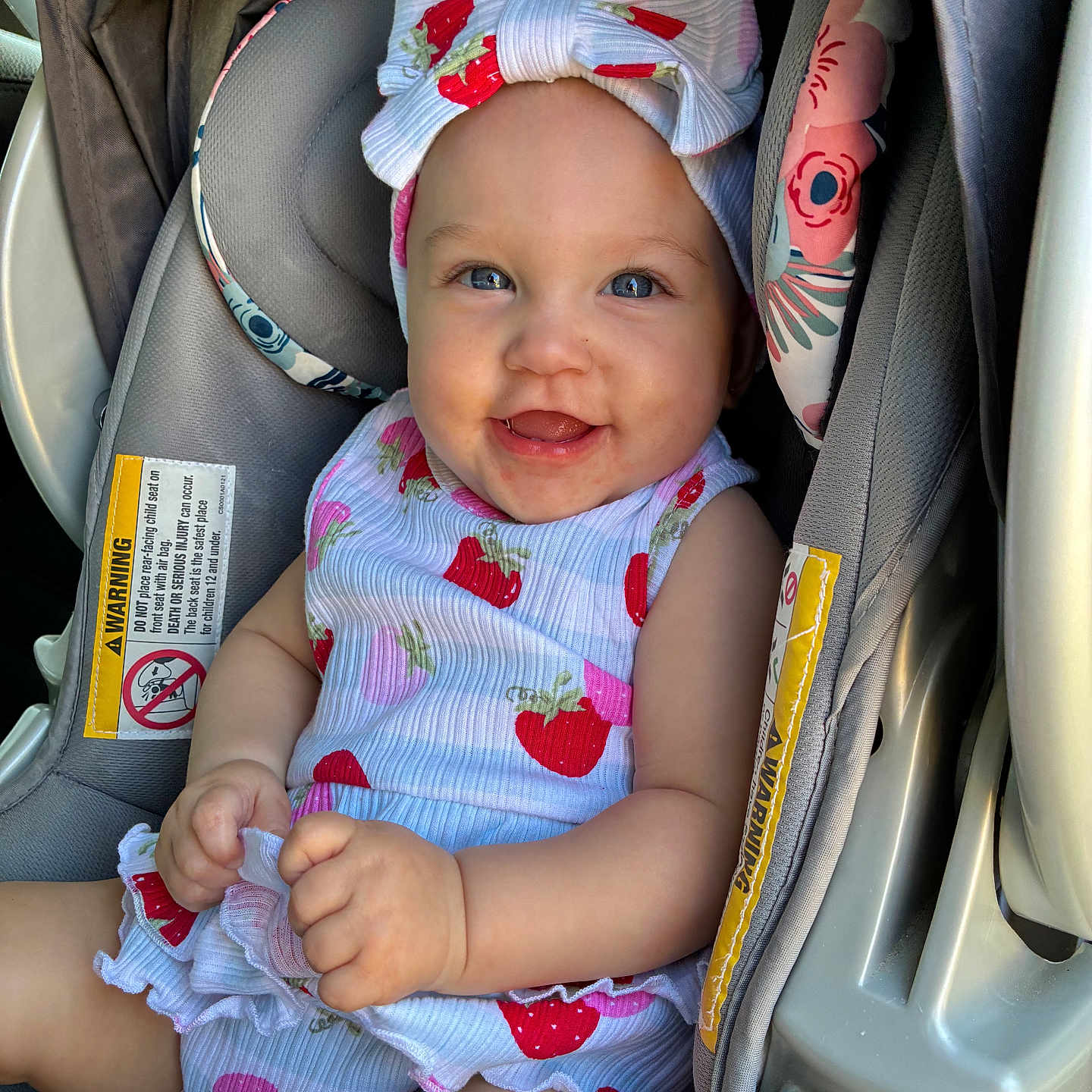 Everly joined the competition — help win amazing prizes! baby, child, car_seat, smiling, headband, strawberry_pattern, clothing, happy, infant, cute, sitting, portrait, person, seatbelt, car_interior, bright, skin, hand, face, eyes