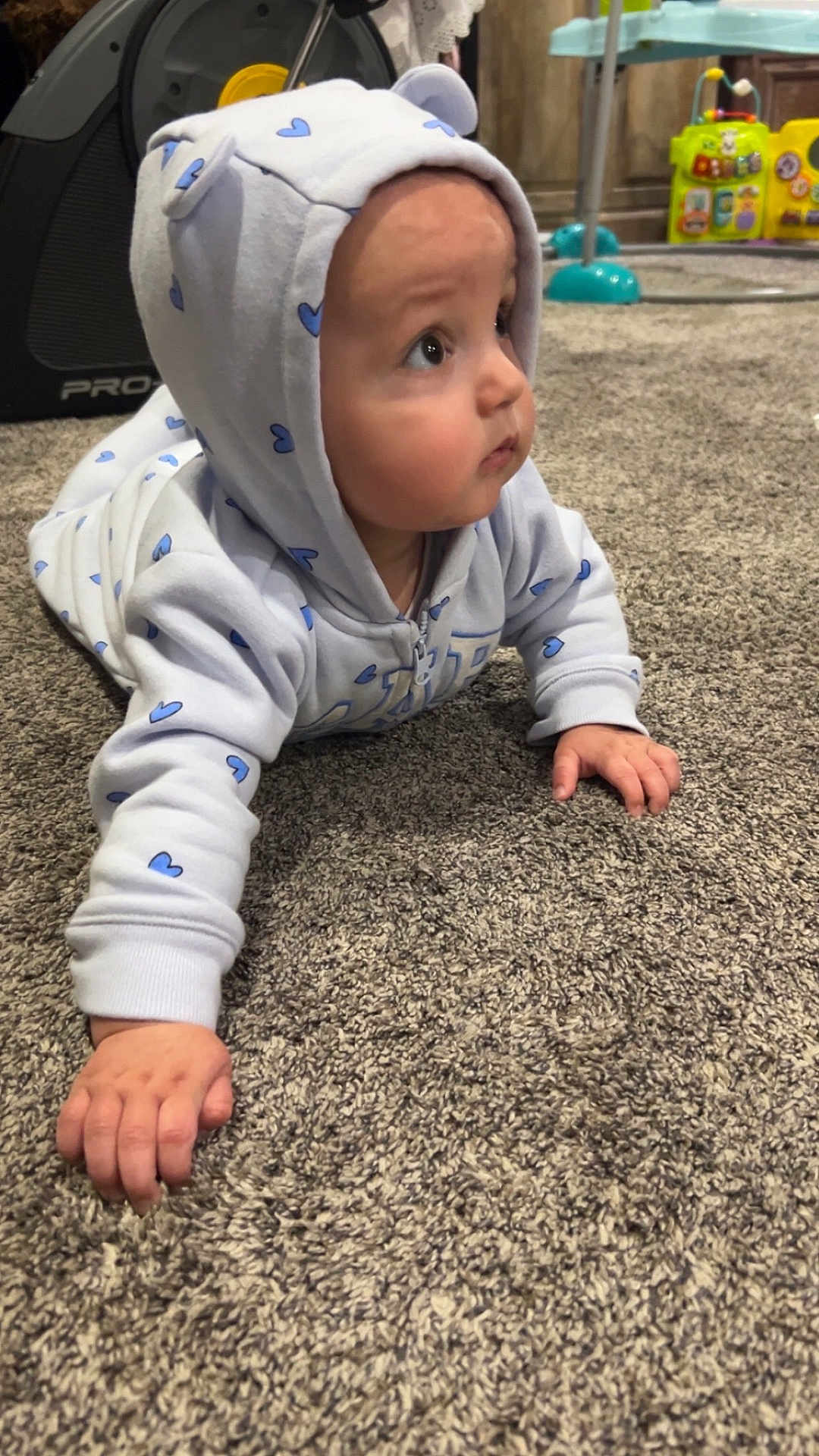 Rowan is registered to the contest to win money with this photo: baby, infant, child, hoodie, heart_pattern, onesie, carpet, crawling, hands, chubby_cheeks, gaze_up, indoor, playroom, toy, floor, portrait, cute, soft_lighting, hood, small_fingers