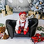 baby, child, smiling, black_couch, red_plaid, hat, bowtie, teddy_bear, toy_truck, christmas_tree, christmas_decorations, wrapped_gifts, holiday, festive, indoor, portrait, happy, cute, seasonal, celebration