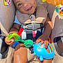 Deheir is registered to the contest to win money with this photo: baby, bright, car_seat, child, closeup, clothing, colorful, cute, daylight, hands, happy, indoors, infant, play, portrait, safety, seat, seatbelt, smiling, toy