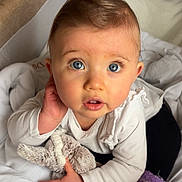 Cataleya participe au concours pour gagner de l'argent avec cette photo : baby, child, blue_eyes, stuffed_animal, white_clothing, purple_socks, blanket, indoors, cute, infant, soft_toys, portrait, close_up, curious, hands, face, young_child, warm, cozy, expression