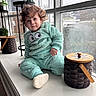 Cito joined the competition — help win amazing prizes! toddler, child, curly_hair, fuzzy_outfit, indoors, window, windowsill, basket, wooden_lid, plant, potted_plant, floor, light, portrait, cozy, casual, clothing, expression, face, sitting