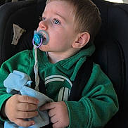 éren participe au concours pour gagner de l'argent avec cette photo : toddler, child, pacifier, green_hoodie, car_seat, blanket, blue_eyes, car_interior, seatbelt, window, daylight, clothing, hand, face, looking_away, young_child, casual_wear, transportation, safety, portrait