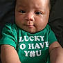 Clover joined the competition — help win amazing prizes! baby, child, infant, green_shirt, text_on_clothing, hands, face, eyes, curly_hair, skin, portrait, cute, young, indoors, expression, front_view, closeup, smile, person, toddler