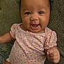 Clover joined the competition — help win amazing prizes! baby, child, smiling, onesie, curly_hair, face, sitting, couch, happy, infant, cute, patterned_clothing, indoor, portrait, person, skin, young_child, cheerful, closeup, furniture