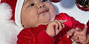 Drake is registered to the contest to win money with this photo: baby, child, christmas, holiday, santa_hat, red_clothing, ornaments, decoration, festive, blanket, cute, infant, portrait, celebration, smiling, hands, face, indoor, seasonal, happy