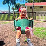 child, toddler, swing, playground, outdoor, smiling, happy, headband, red_clothing, shoes, socks, grass, trees, fence, sunny, daytime, baby, park, fun, play