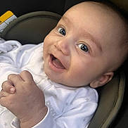 Mikaeel is registered to the contest to win money with this photo: baby, infant, smiling, happy, face, hands, white_clothing, onesie, cushion, seat, closeup, portrait, child, cute, skin, eyes, expression, indoor, newborn, cozy