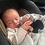 baby, sleeping, blanket, car_seat, soft_toy, infant, child, peaceful, cute, hands, clothing, indoors, portrait, closeup, resting, cozy, comfort, gentle_light, toddler, young_child