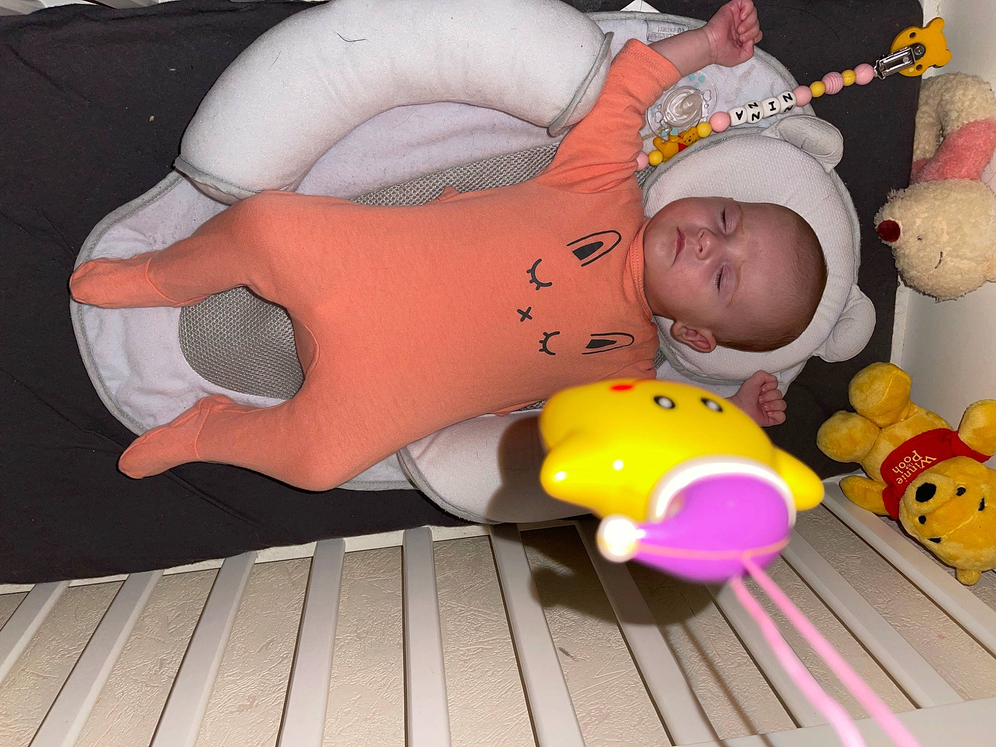 Nina a rejoint le concours — aidez-le/la à gagner de superbes lots ! baby, baby_products, baby_toddler_clothing, baby_toys, child, comfort, flooring, fun, happy, hat, orange, party_supply, person, pink, plastic, plush, stuffed_toy, thigh, toddler, toy