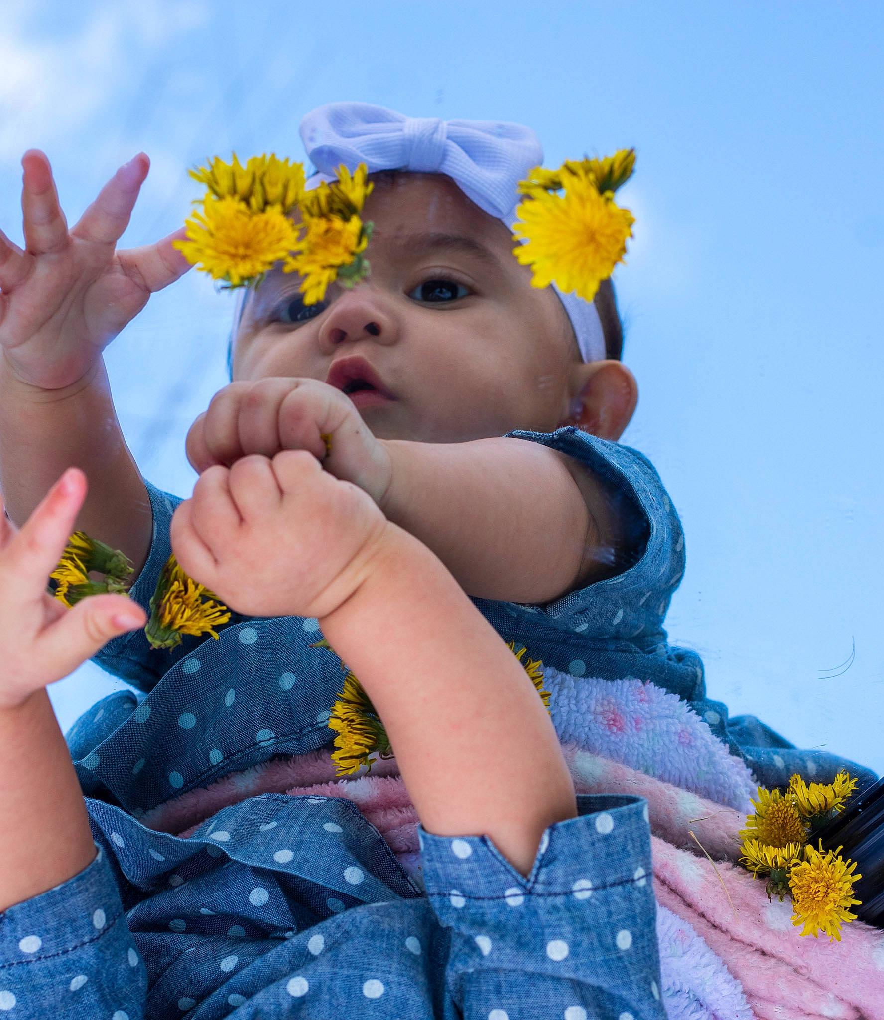 Camila is registered to the contest to win money with this photo: arm, baby, baby_toddler_clothing, cloud, finger, flower, fun, gesture, grass, hand, happy, headwear, leaf, people_in_nature, person, petal, plant, sky, textile, thumb