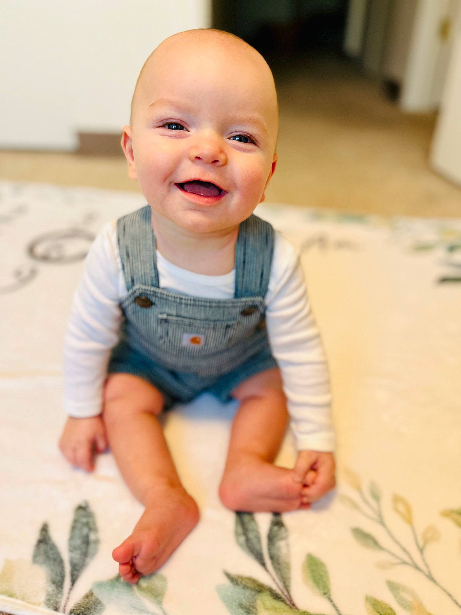 Chandler is registered to the contest to win money with this photo: arm, baby, baby_toddler_clothing, cheek, child, finger, floor, flooring, fun, happy, joy, people_in_nature, person, petal, sitting, skin, sleeve, smile, standing, t_shirt