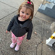Elaina is registered to the contest to win money with this photo: toddler, child, girl, outdoor, sidewalk, pink_bow, black_jacket, pink_pants, pink_shoes, smile, face, hair, curious, standing, urban, concrete, clothing, person, casual, daylight