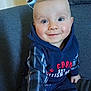 Juliann a rejoint le concours — aidez-le/la à gagner de superbes lots ! baby, child, smiling, blue_eyes, hoodie, plaid, sitting, couch, indoor, happy, person, cute, young, face, clothing, portrait, infant, rosy_cheeks, casual, comfort
