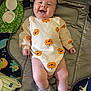Ronin is registered to the contest to win money with this photo: baby, baby_accessories, child, colorful, comfort, cute, face, gray_socks, happy, indoor, infant, joy, lying_down, onesie, padded_mat, person, playmat, pumpkin_pattern, smiling, toy