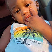 Tru is registered to the contest to win money with this photo: toddler, child, face, hand, fingers, tank_top, sunlight, car_interior, earring, person, portrait, holding, container, skin, young_child, casual_clothing, window, closeup, expression, seated