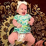 baby, smiling, child, infant, headband, dress, carpet, pattern, sock, hand, tattoo, ring, happy, lying_down, cute, indoor, person, skin, human, baby_clothing