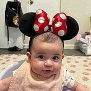 Alexus is registered to the contest to win money with this photo: baby, baby_seat, bag, bib, bow, carpet, child, clothing, cute, door, expression, face, floor, headband, home, indoor, infant, minnie_mouse, person, polka_dot