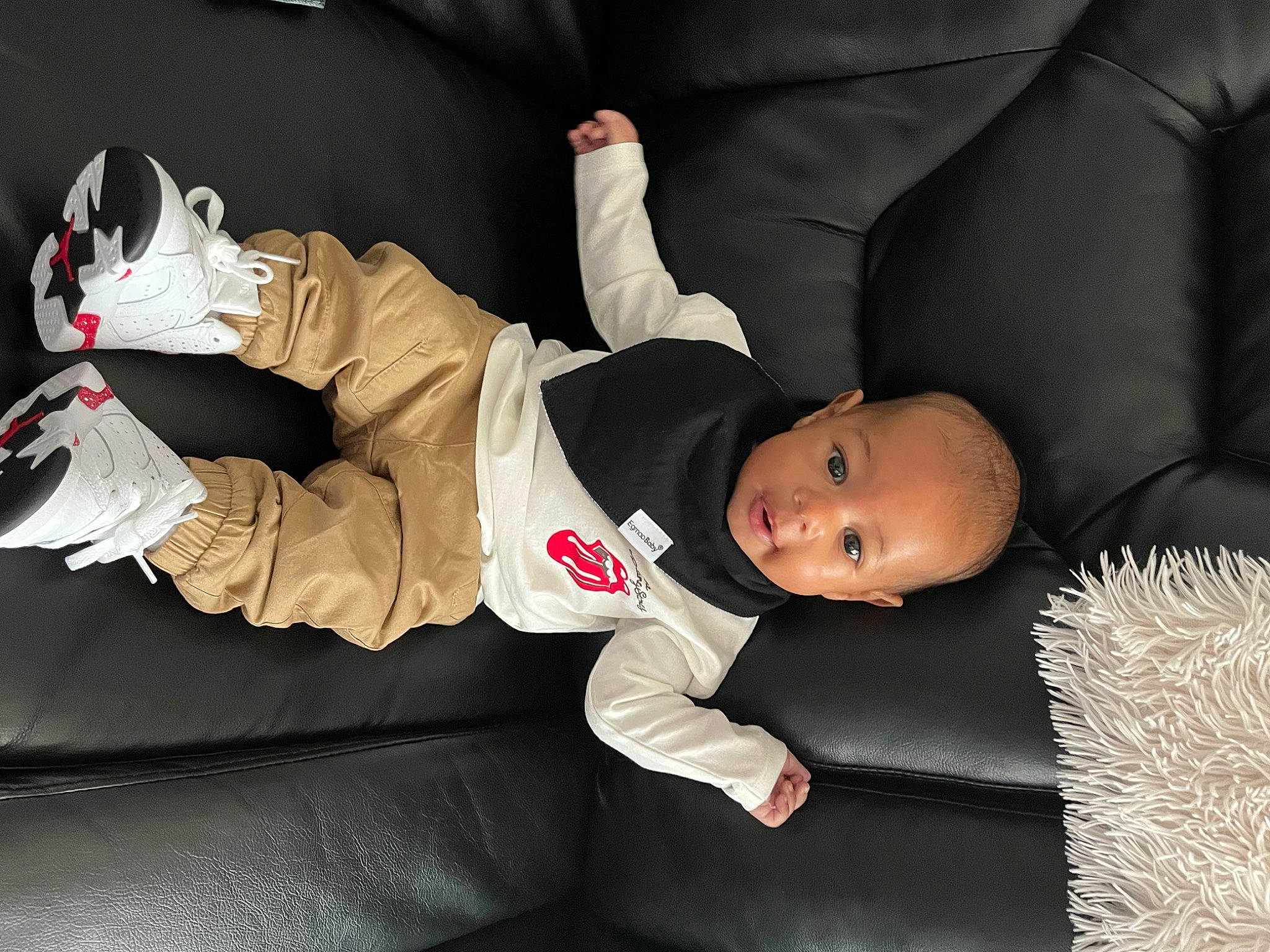 Jonas is registered to the contest to win money with this photo: baby, baby_toddler_clothing, carmine, child, comfort, couch, flooring, fun, fur, knee, mammal, person, room, sitting, sneakers, sock, toddler