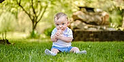 Kohen is registered to the contest to win money with this photo: baby, child, cute, daylight, grass, greenery, infant, innocent, nature, outdoor, playful, portrait, rocks, shorts, sitting, sock, summer, trees, white_shirt, young_child