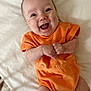 Adalynn is registered to the contest to win money with this photo: baby, infant, smiling, orange_clothing, lying_down, happy, cute, child, portrait, skin, hands, feet, white_background, expression, joy, casual, one_person, indoors, newborn, closeup