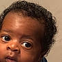 Ace joined the competition — help win amazing prizes! baby, close_up, curly_hair, wide_eyes, blue_clothing, infant, face, portrait, skin, expression, child, hand, young, cute, person, indoor, head, looking, mouth_open, background
