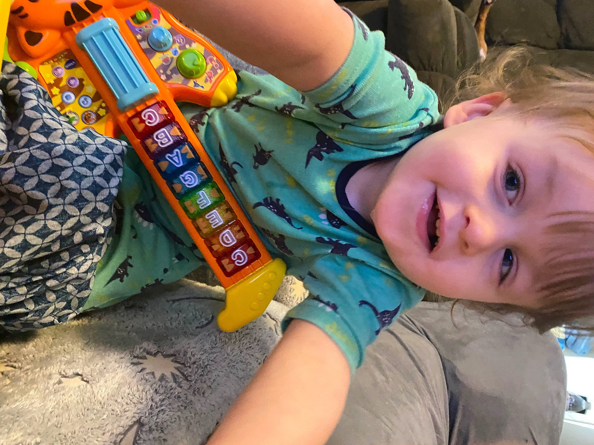 Caiden is registered to the contest to win money with this photo: child, electric_blue, fun, grass, happy, joy, leisure, longboard, person, play, power_tool, recreation, sitting, skateboard, skateboard_truck, skateboarding_equipment, smile, soil, t_shirt, toddler