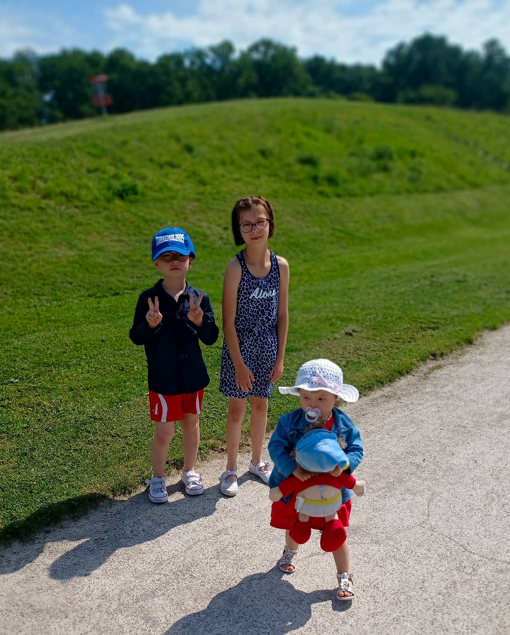 Lya a rejoint le concours — aidez-le/la à gagner de superbes lots ! asphalt, child, cloud, electric_blue, fun, grass, grassland, hat, headwear, landscape, leisure, people_in_nature, person, plant, recreation, road, sky, summer, sun_hat, toddler
