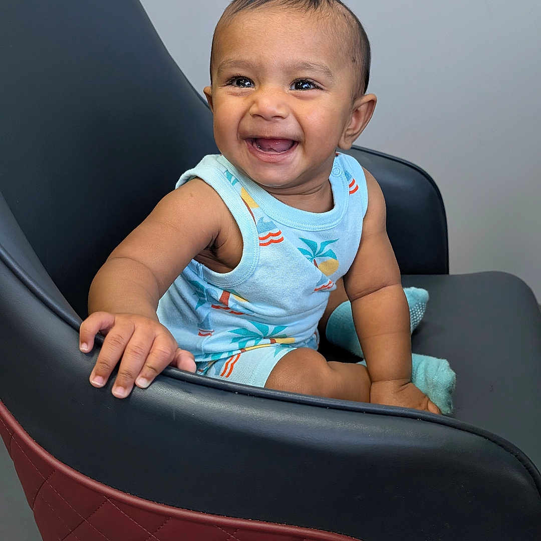 Viraj Reddy is registered to the contest to win money with this photo: baby, child, smiling, happy, sitting, chair, blue_outfit, indoor, modern_furniture, cute, portrait, one_person, short_hair, skin, hand, footwear, baby_clothes, infant, baby_boy, room