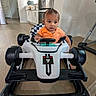 Viraj Reddy joined the competition — help win amazing prizes! toddler, baby, walker, toy_car, orange_shirt, indoor, kitchen, wooden_floor, child, person, floor, steering_wheel, concentration, seat, modern_kitchen, appliance, cabinet, door, car_toy, racing