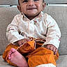 baby, child, smiling, sitting, couch, clothing, happy, face, foot, indoors, person, portrait, cute, infant, young_child, fabric, home, relaxed, casual, comfortable