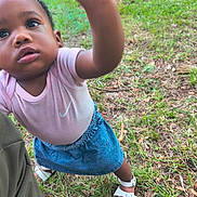 A'Yari joined the competition — help win amazing prizes! toddler, child, outdoor, grass, curious, denim_skirt, pink_shirt, white_sandals, reaching_hand, close_up, nature, young_child, exploration, casual_clothing, summer, person, portrait, grass_field, daylight, cute